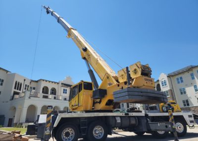 Blue's Crane Service crane placing an HVAC unit on top of a building.