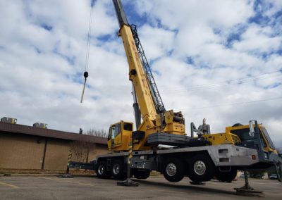 Blue's Crane Service Crane with rigging on its hook about to make a pick off of a building.