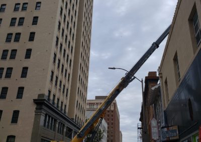 Blue's Crane Service performing a lift between buildings in downtown Fort Worth Texas.