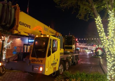 Blue's Crane Service crane on the road surrounded by Christmas Lights.