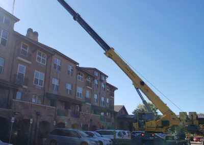 Blue's Crane Service safely performing a lift according to their lift plan outside of an apartment building.