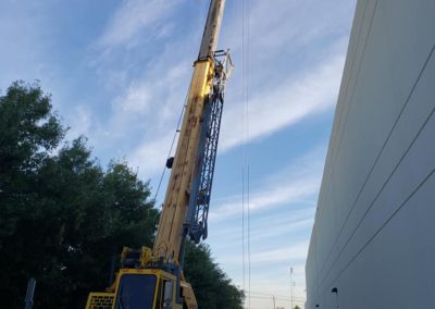 Blue's Crane Service crane ready for a lift on the side of a building.