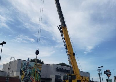 Blue's Crane Service crane lifting an HVAC unit at Schlotzsky's.