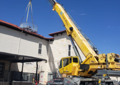 Blue's Crane Service crane lifting a platform with rails.