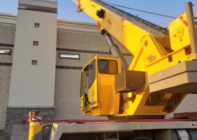 Blue's Crane Service crane placing it's lift on a rooftop.