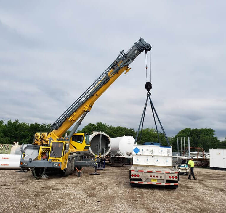 Blue's Crane Service crane lifting from a flatbed trailer.