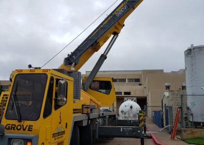 Blue's Crane Service crane stabilized at a jobsite with it's boom extended.