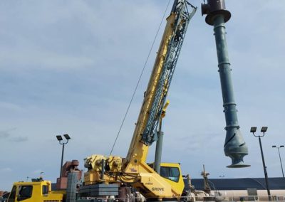 Blue'd Crane Service crane lifting material at a jobsite.